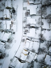 an aerial view of a neighborhood covered in snow