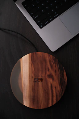 A stylish wireless charger with a gold accent on a minimalist desk setup