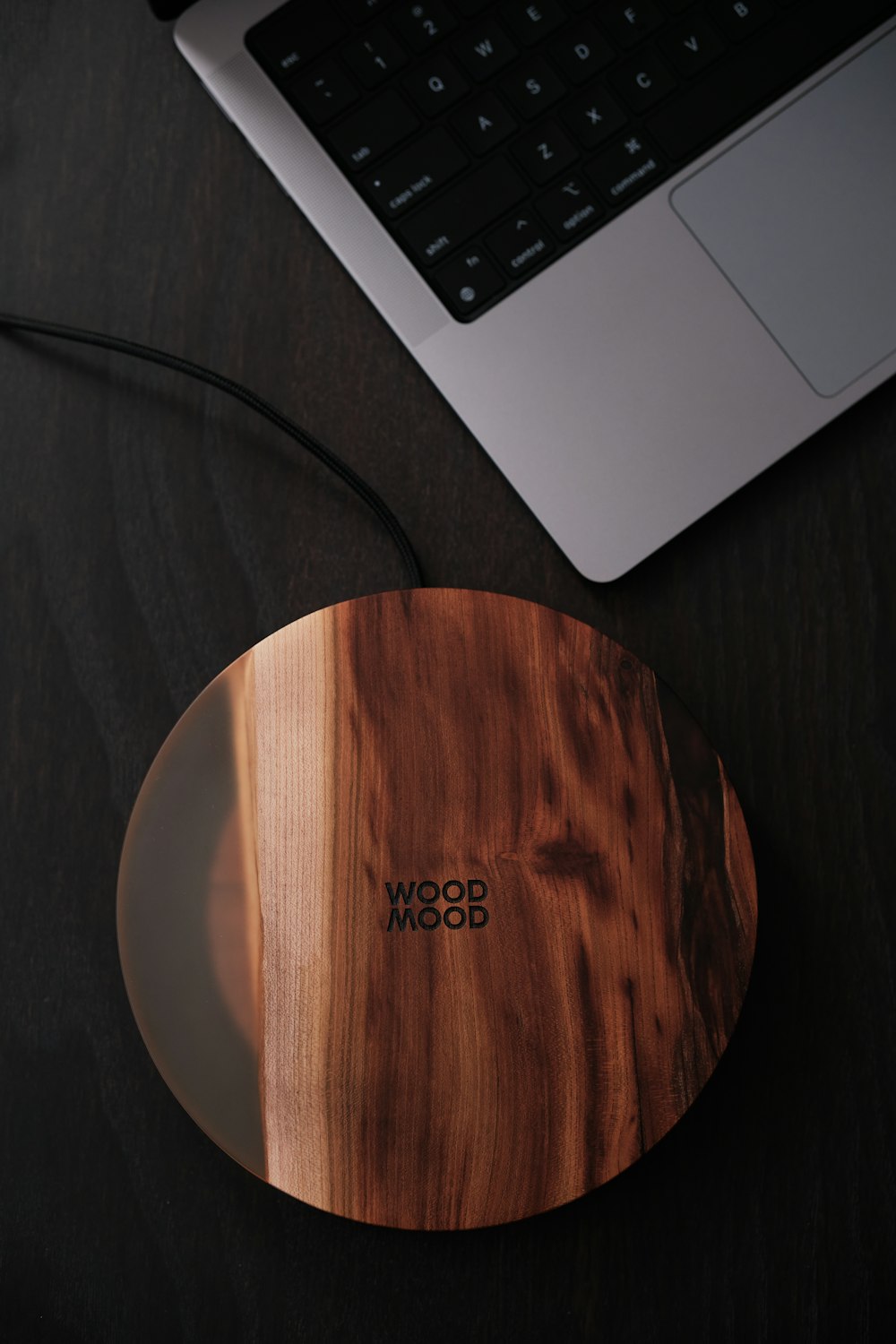 a wooden mouse pad sitting next to a laptop