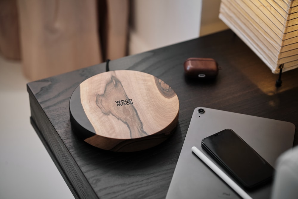 a wooden plate sitting on top of a table next to a laptop