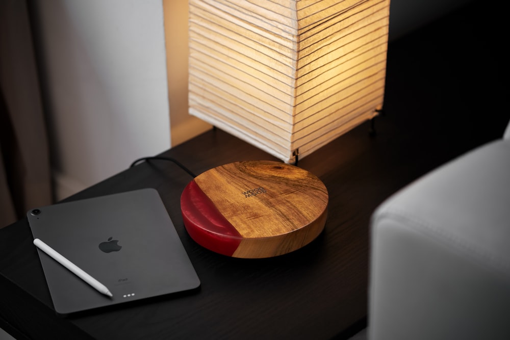 a wooden table with a laptop and a lamp on it