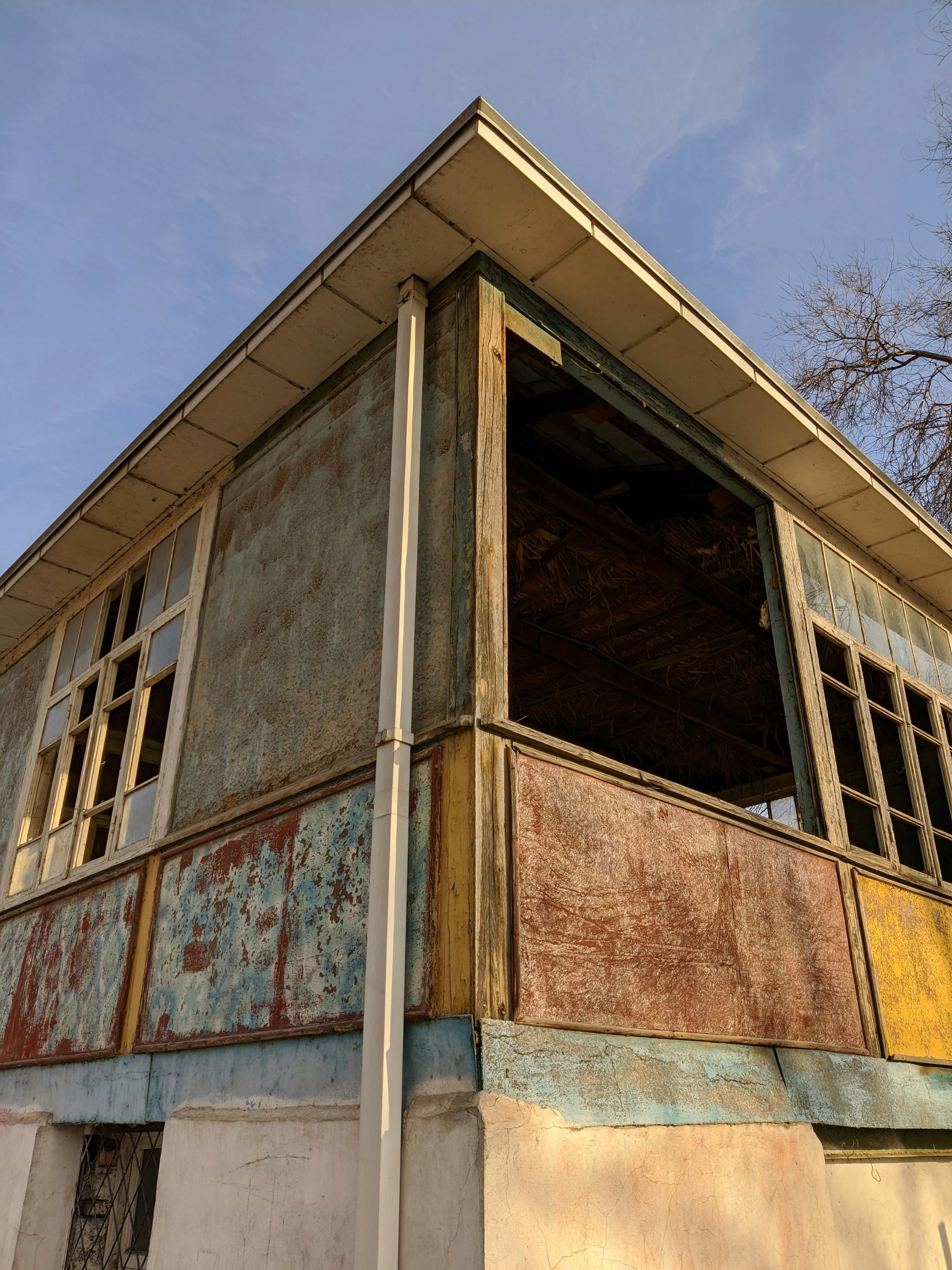 an old building with peeling paint and a broken window