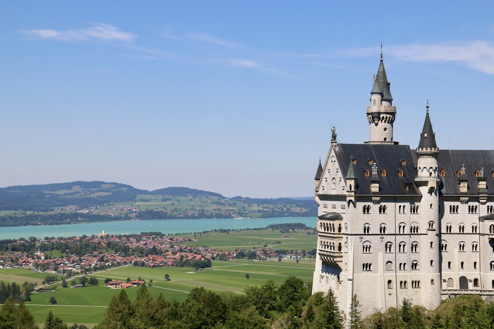 a castle with a view of a lake and mountains in the background