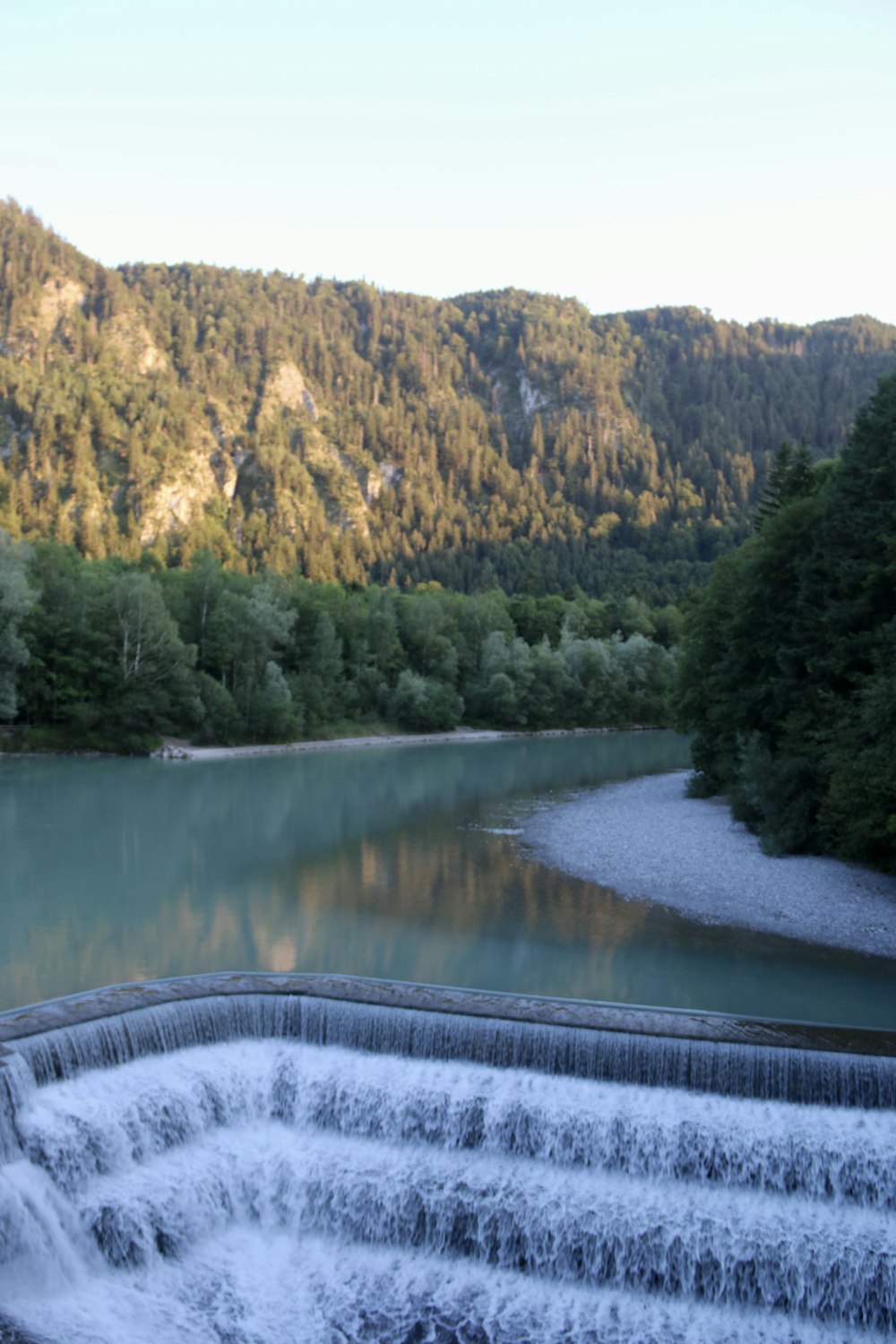 un grand plan d’eau entouré d’une forêt