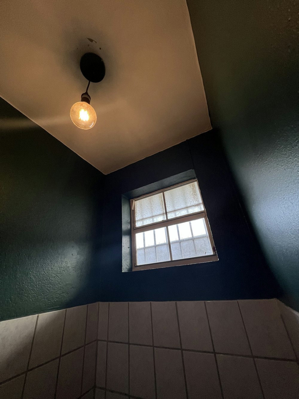 a bathroom with a window and tiled floor