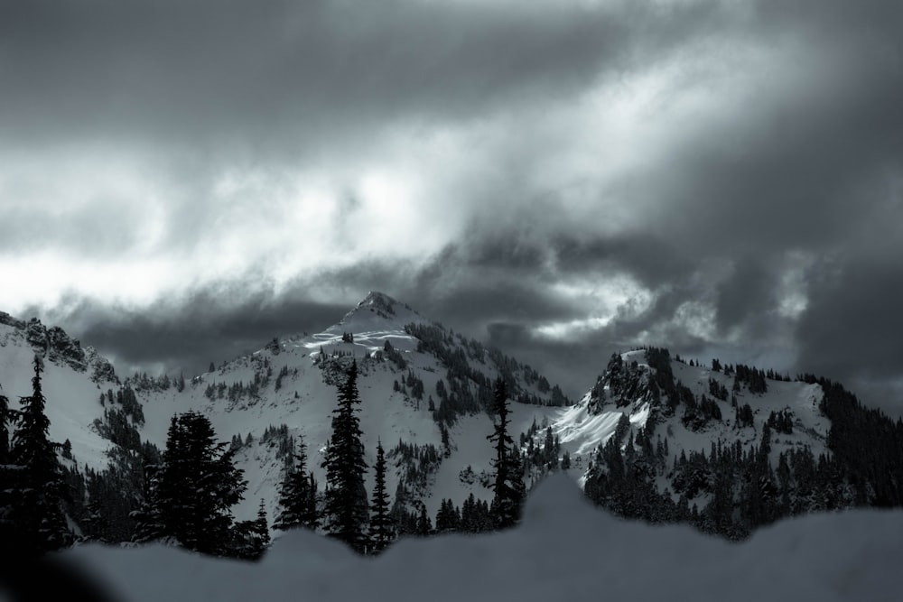 a mountain covered in snow under a cloudy sky