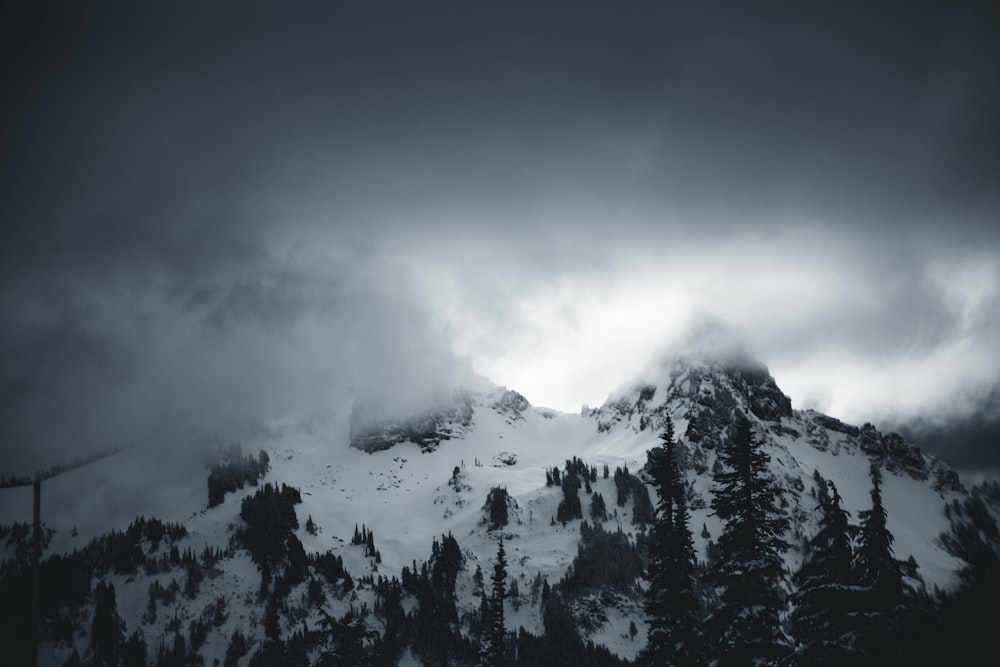 a mountain covered in snow under a cloudy sky