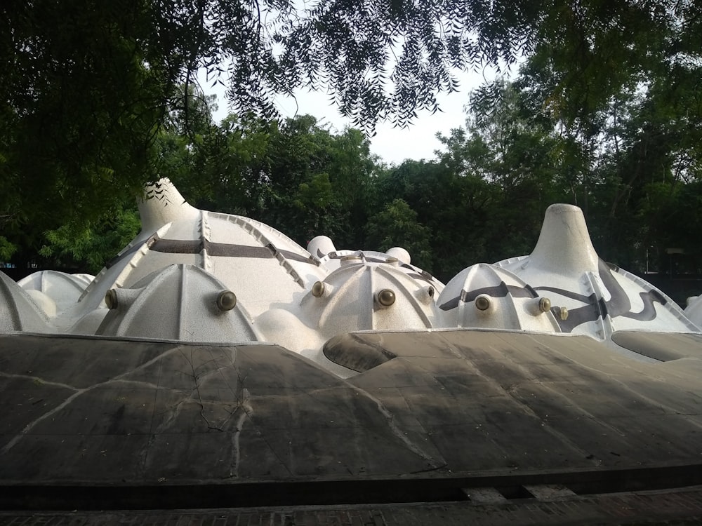 a group of white sculptures with trees in the background