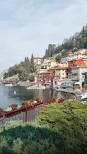 A quaint village street bursting with colorful houses and lively market stalls near the lake.