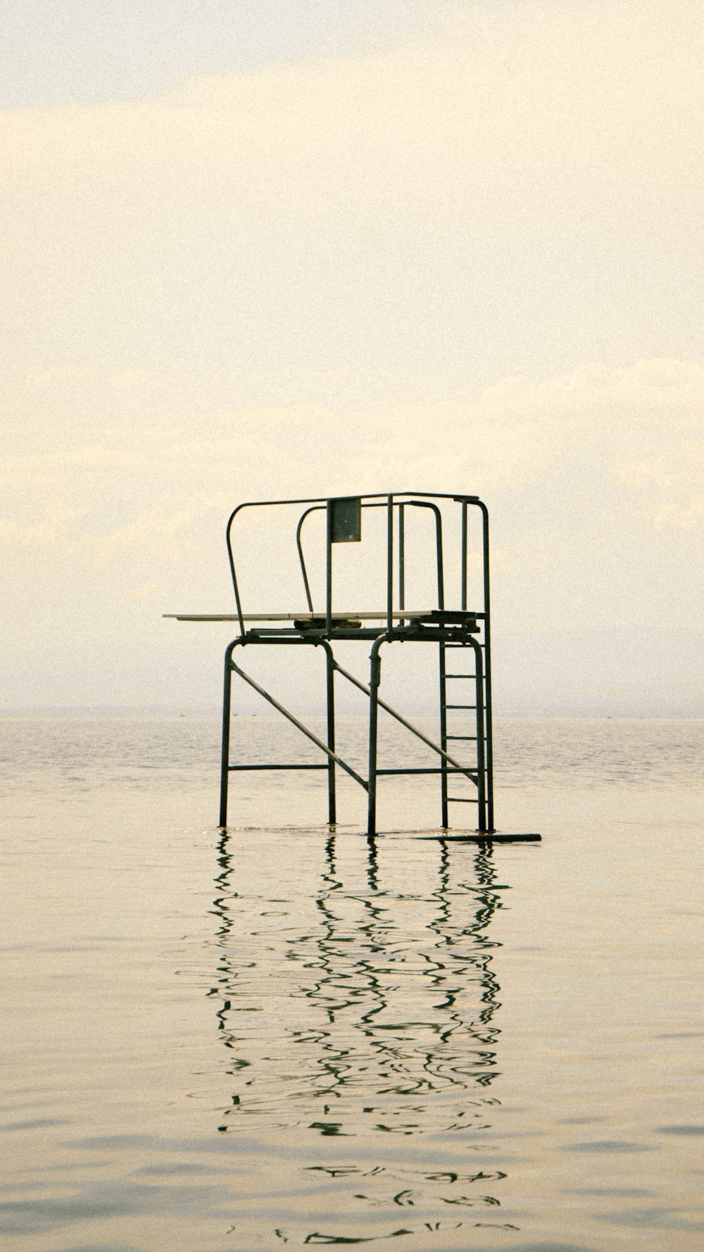a chair sitting on top of a metal structure in the water