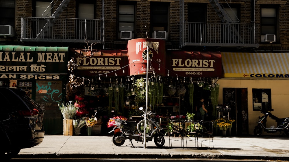 a motorcycle parked in front of a flower shop