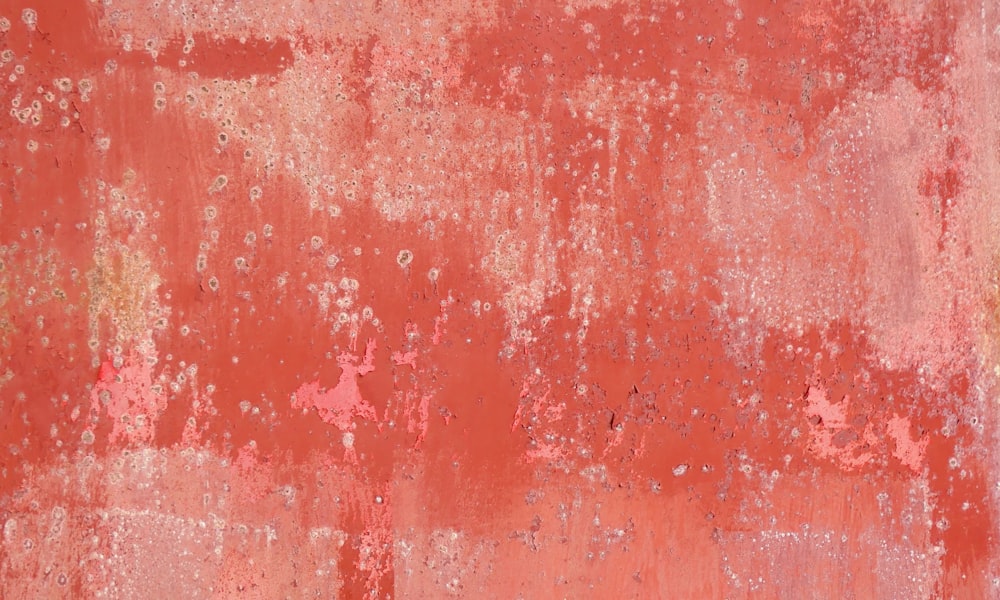 a red wall with white and yellow paint on it