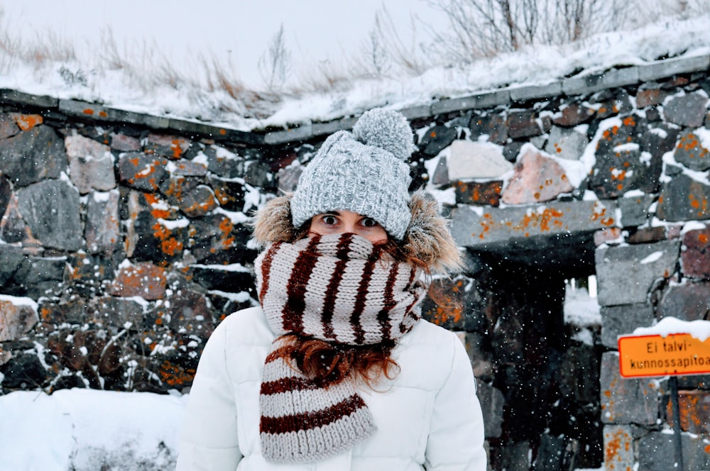 a woman wearing a hat and scarf in the snow