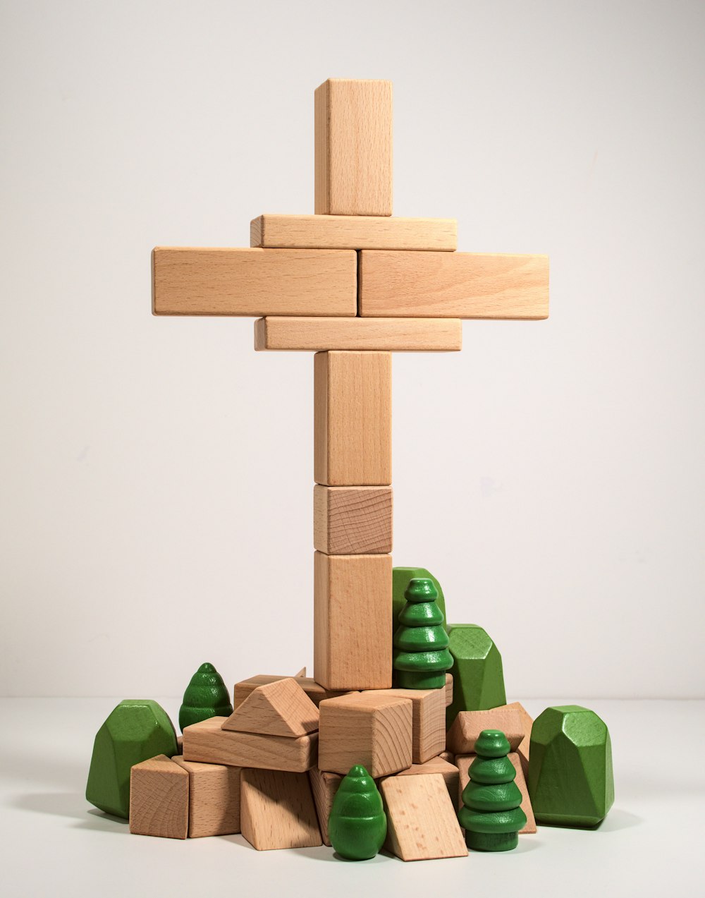 a wooden cross surrounded by blocks and trees