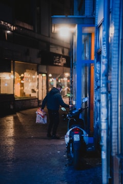 Street shot of a person wearing cargo pants with neon accents walking through a dimly lit alley.