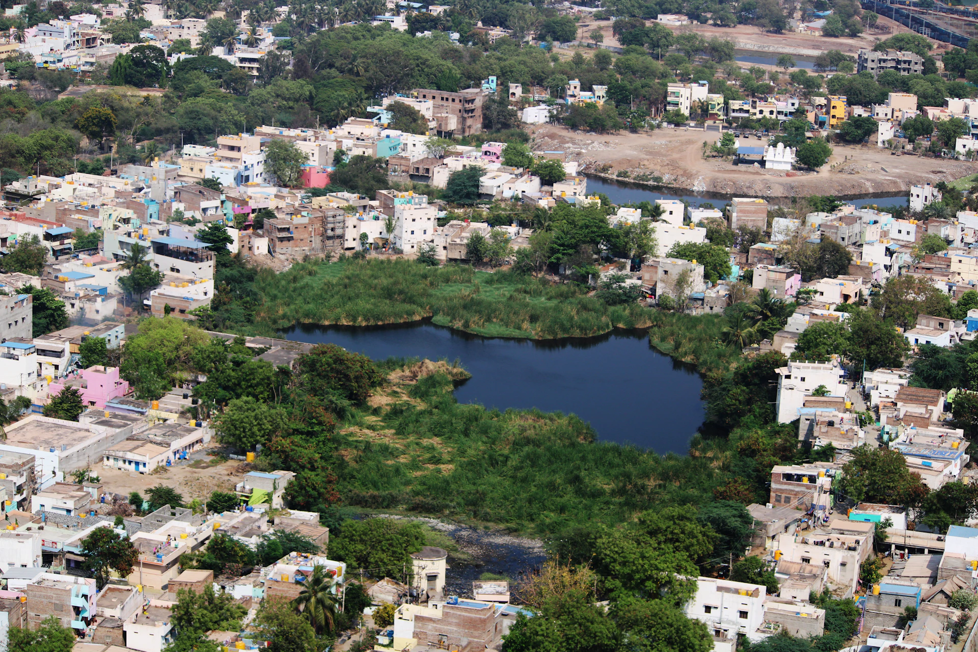 An aerial view of a cluster of innovative floating homes arranged harmoniously on a serene lake.