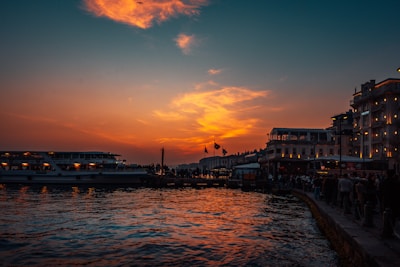 A vibrant scene of Tuxpan's waterfront at sunset, with a camera crew filming a local event.