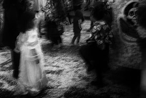Children in costumes walking along a winding haunted path lined with eerie lanterns.