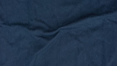 Close-up of luxurious fabric textures in deep blue and metallic tones.