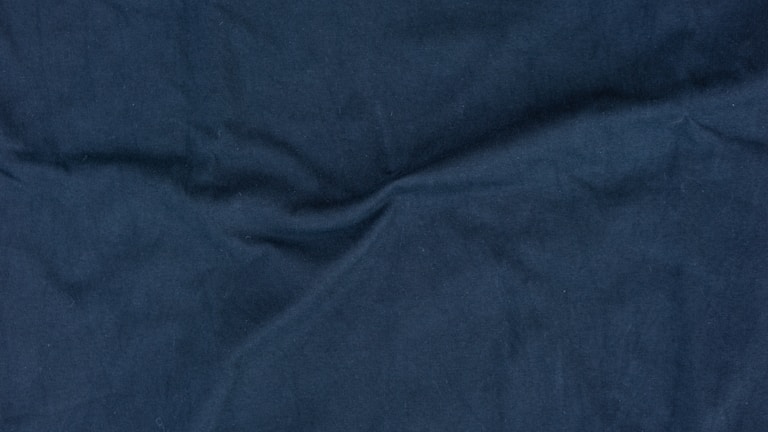 Close-up of rich navy blue wool fabric with fine texture.