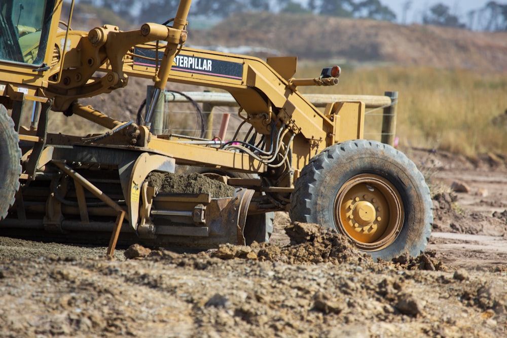 Ein gelber Traktor ist im Dreck geparkt