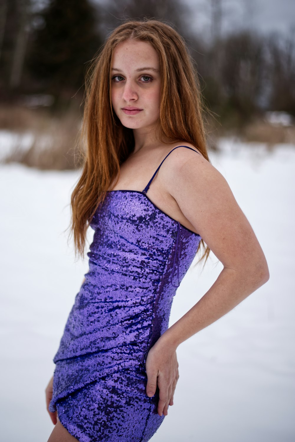 a woman in a purple dress posing in the snow