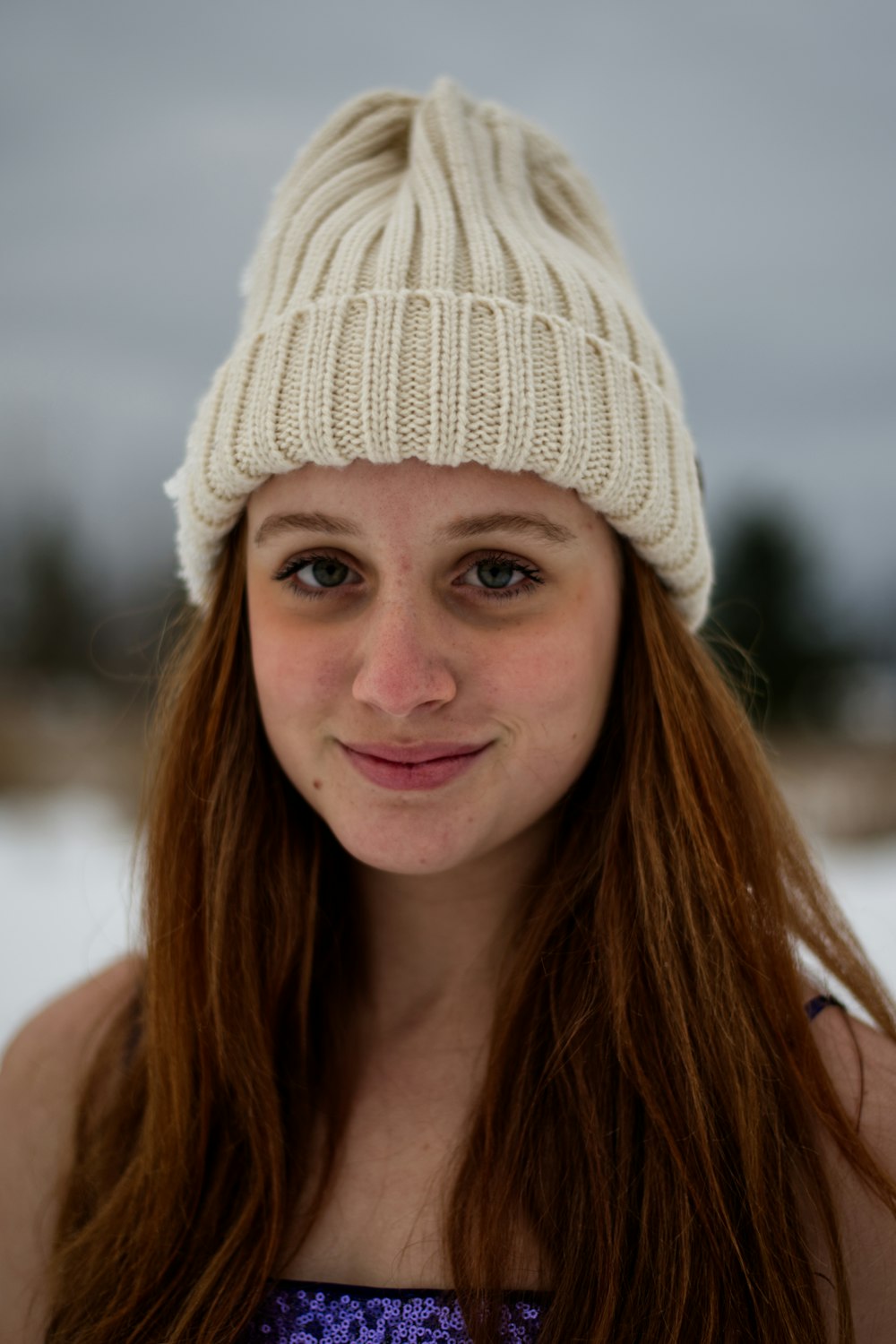 a woman with long hair wearing a white hat