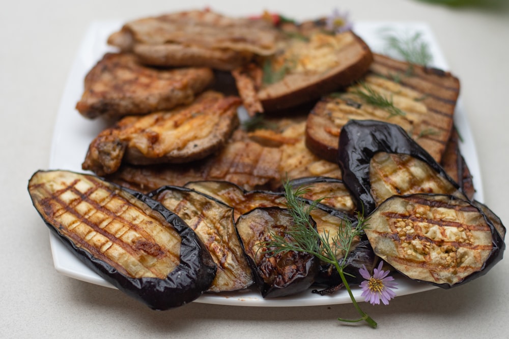 a white plate topped with grilled eggplant and potatoes