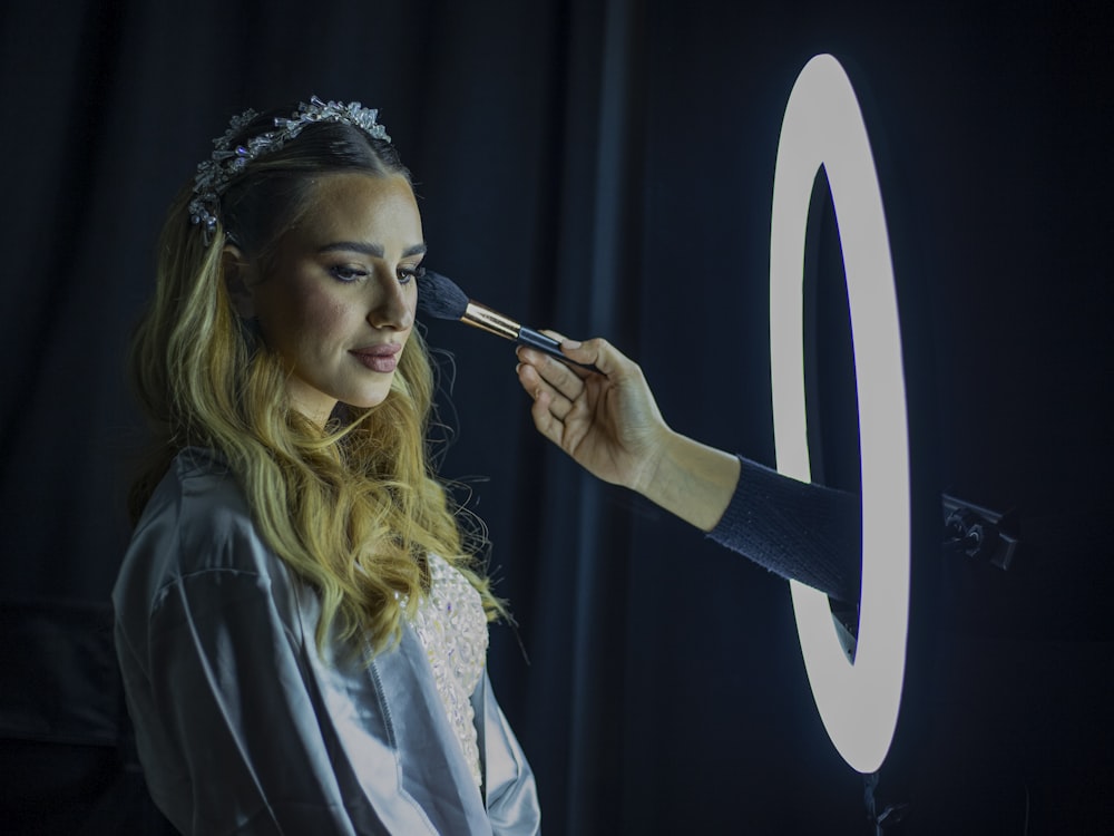 a woman is getting her make up done