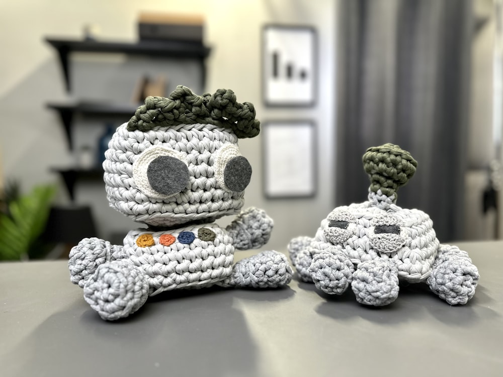 two crocheted toys sitting on top of a table