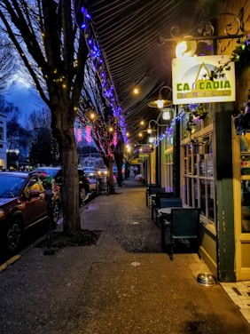 A cozy Beaverton street scene featuring a halal restaurant with inviting outdoor seating under string lights.