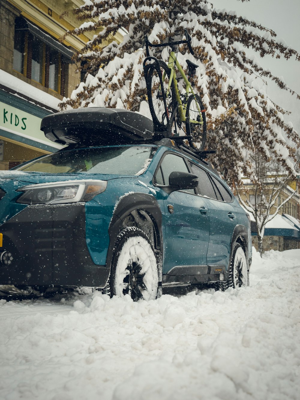 ein Auto mit einem Fahrrad obendrauf, das im Schnee geparkt ist