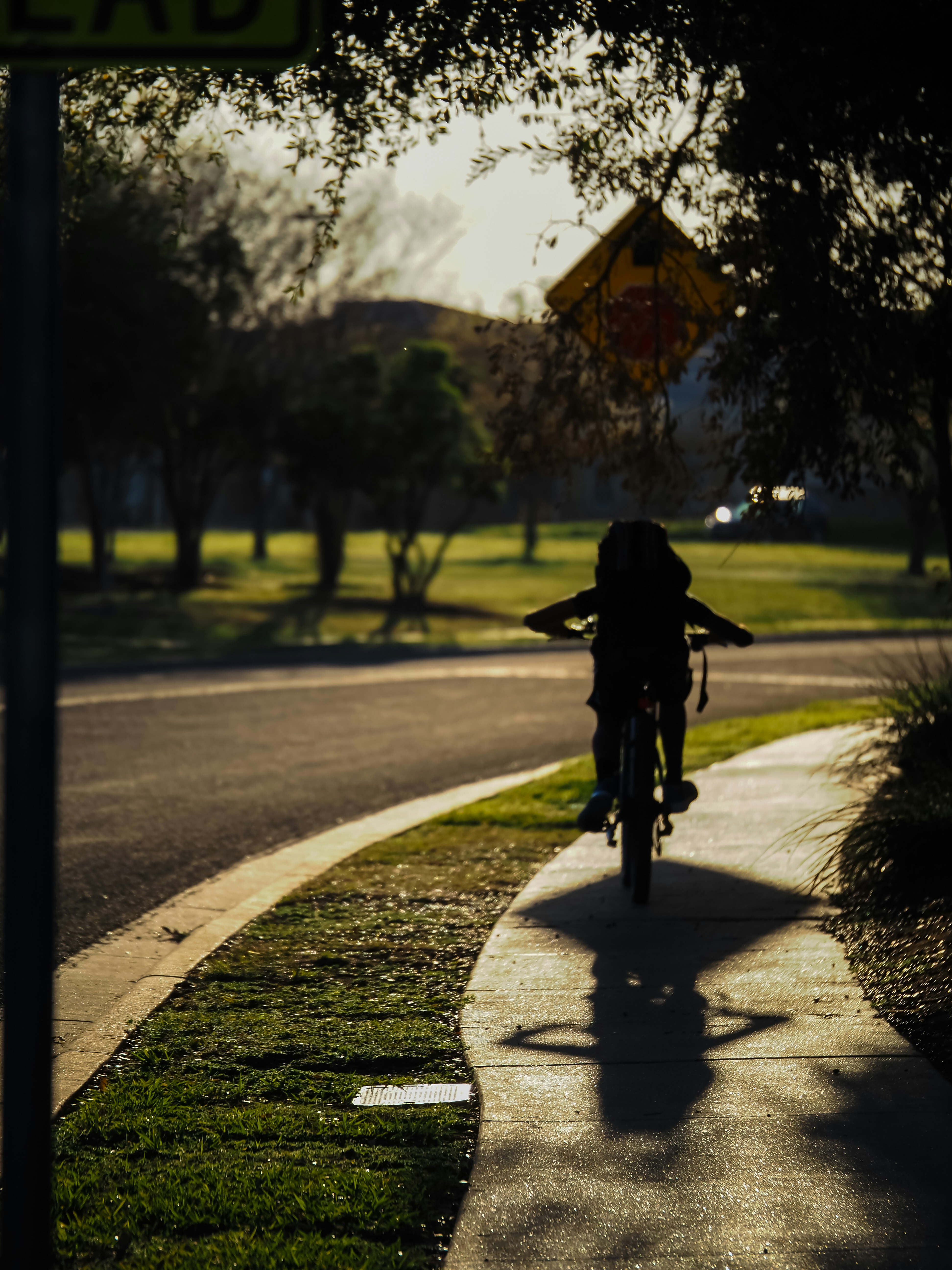 Teens playing basketball on an outdoor court in the evening