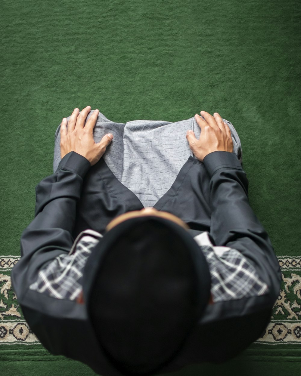 a man laying on a rug with his hands on his head