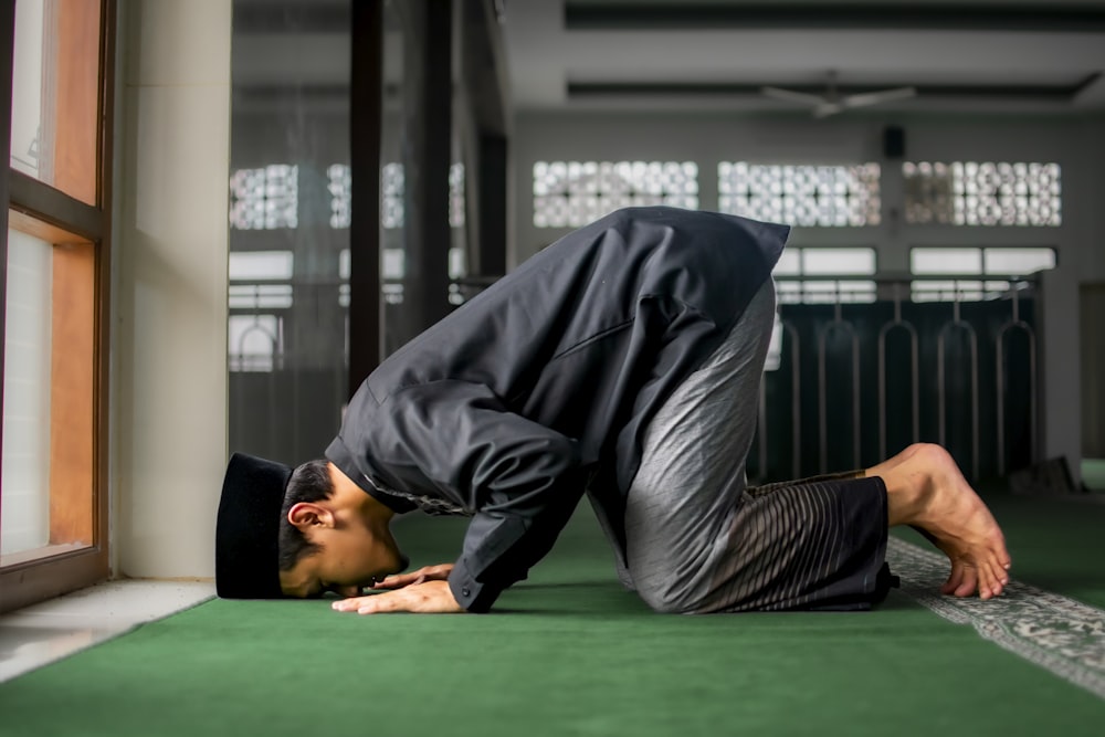 a man in a suit is doing a handstand on the floor