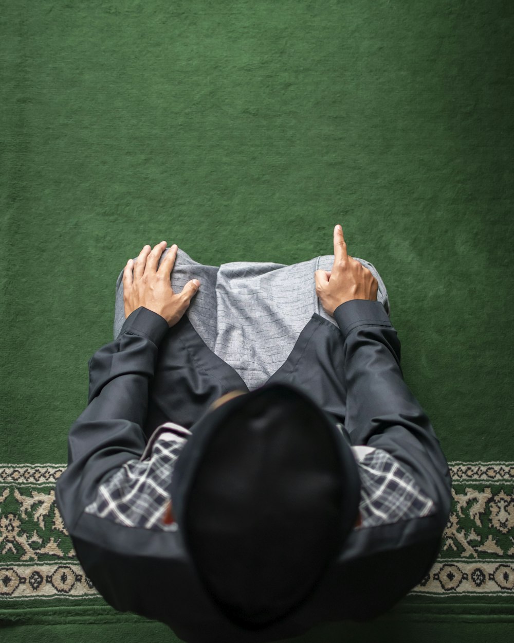 a man laying on a rug with his hands on his chest