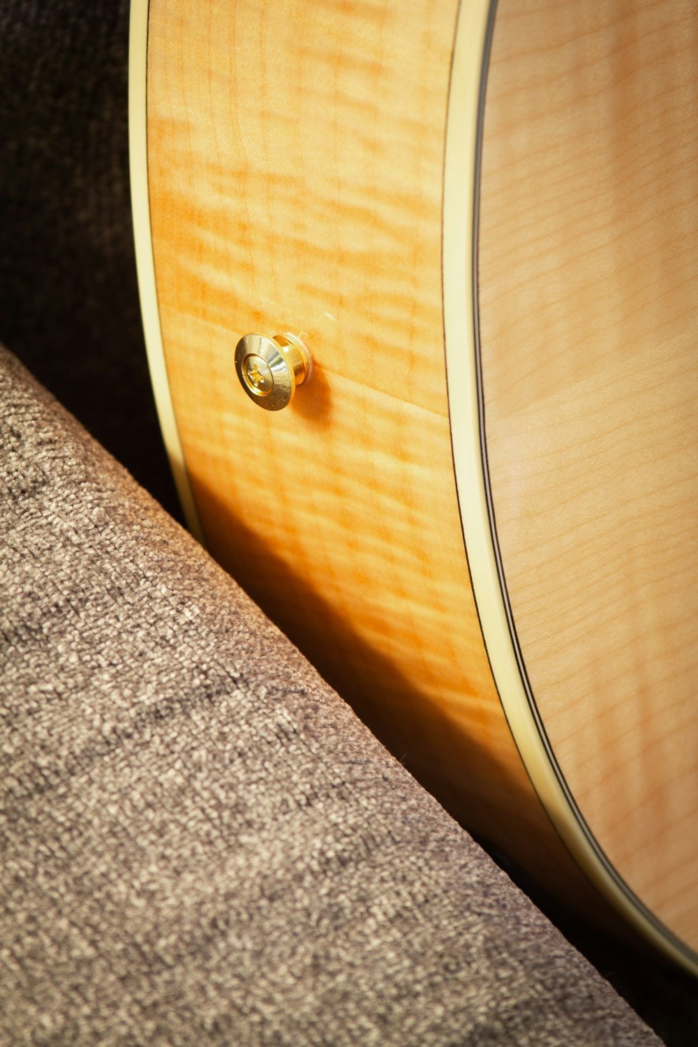 a close up of a guitar neck and a couch