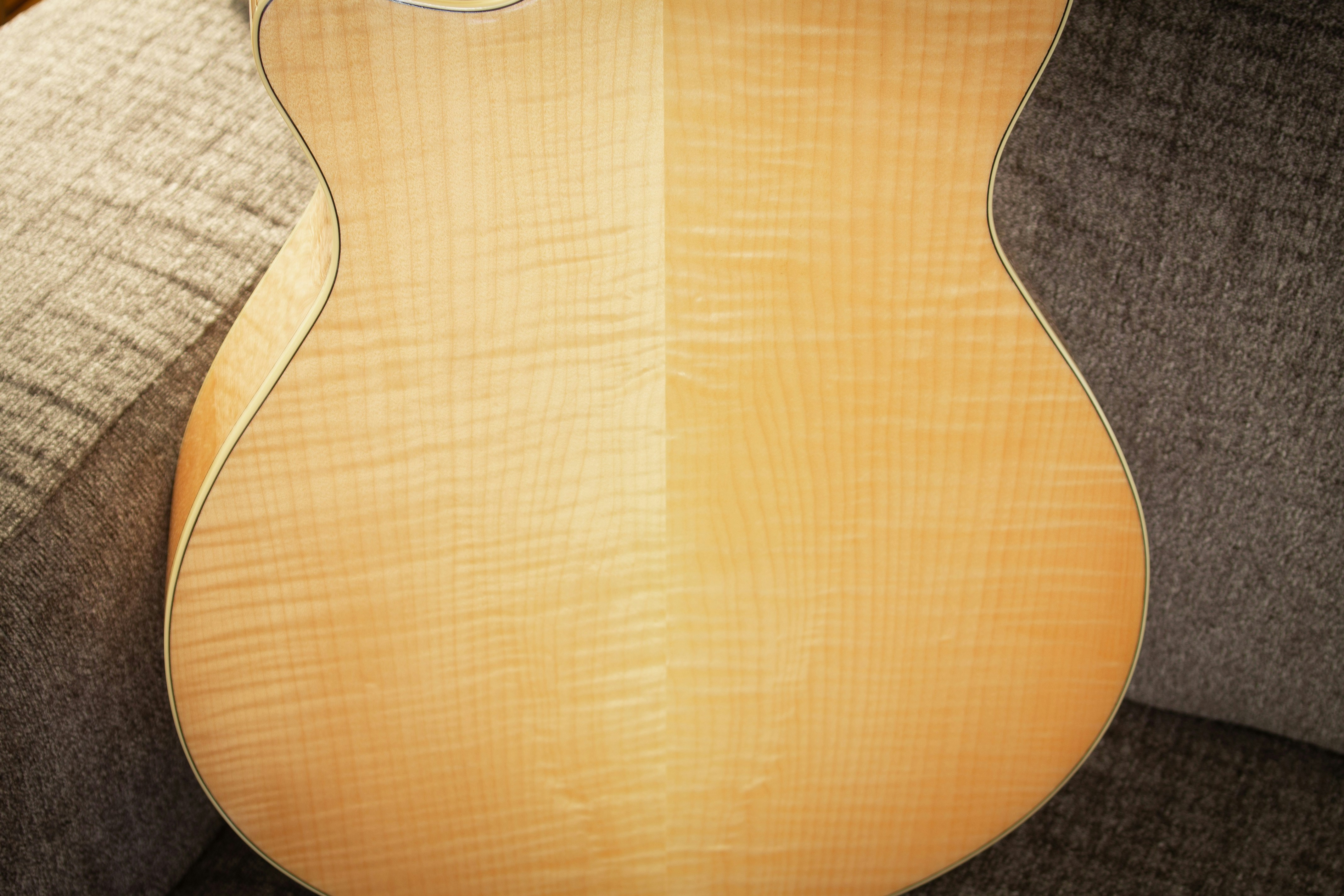 a close up of a guitar sitting on a couch