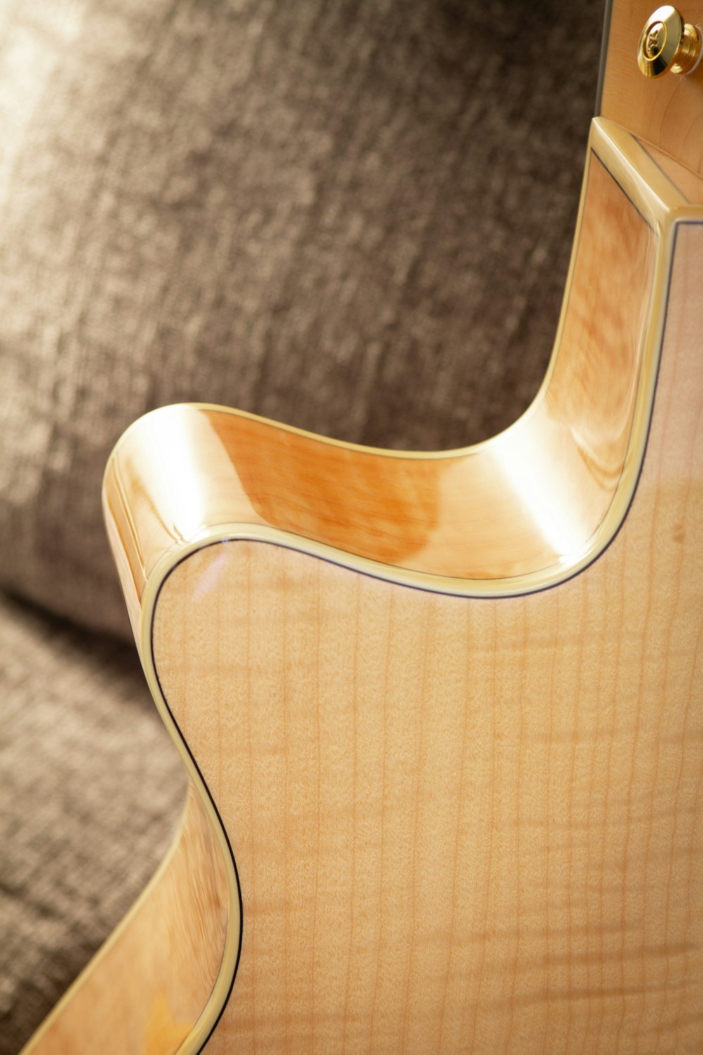 a close up of a guitar neck on a couch