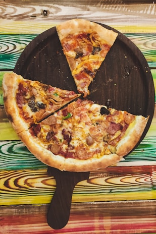 A rustic wooden board displaying a variety of pizza slices with different toppings, inviting and ready to eat.