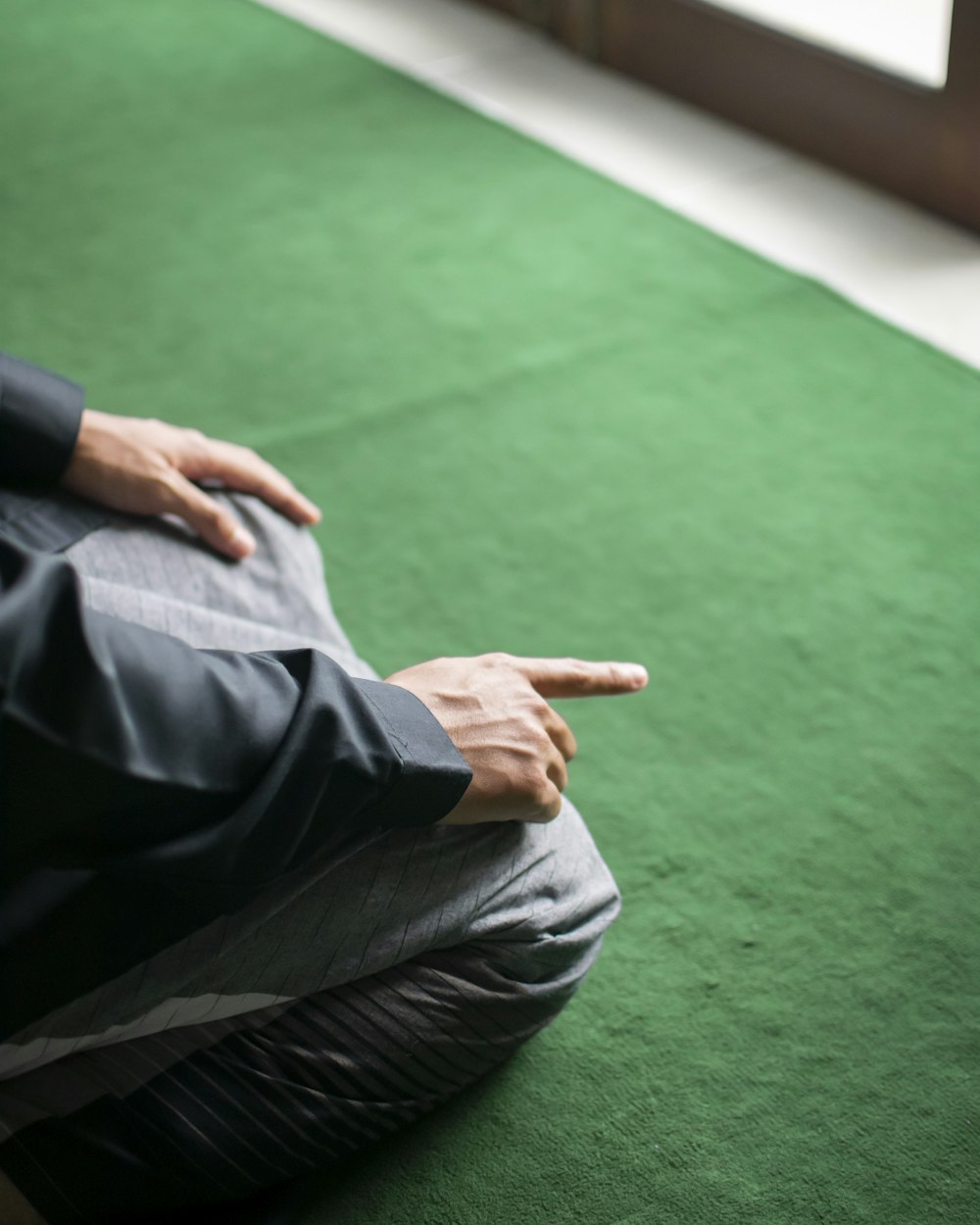 a person sitting on the ground pointing at something