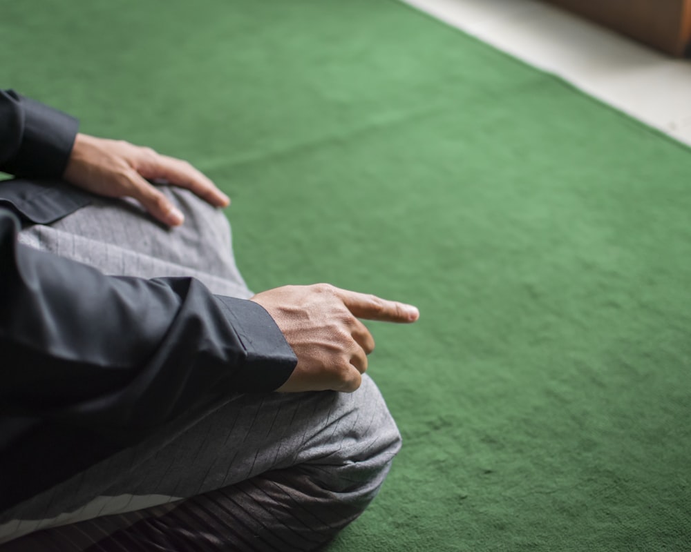 a person sitting on the ground pointing at something