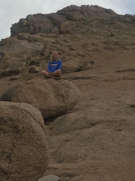 Ecuadorian elite athlete meditating at sunrise on Cotopaxi volcano with volcanic rock textures