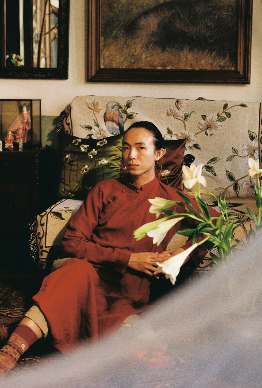 a woman sitting on a couch holding a bouquet of flowers