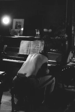 A moody, emotional scene from a sad song video with Deshdeep Rawat in a dimly lit room.
