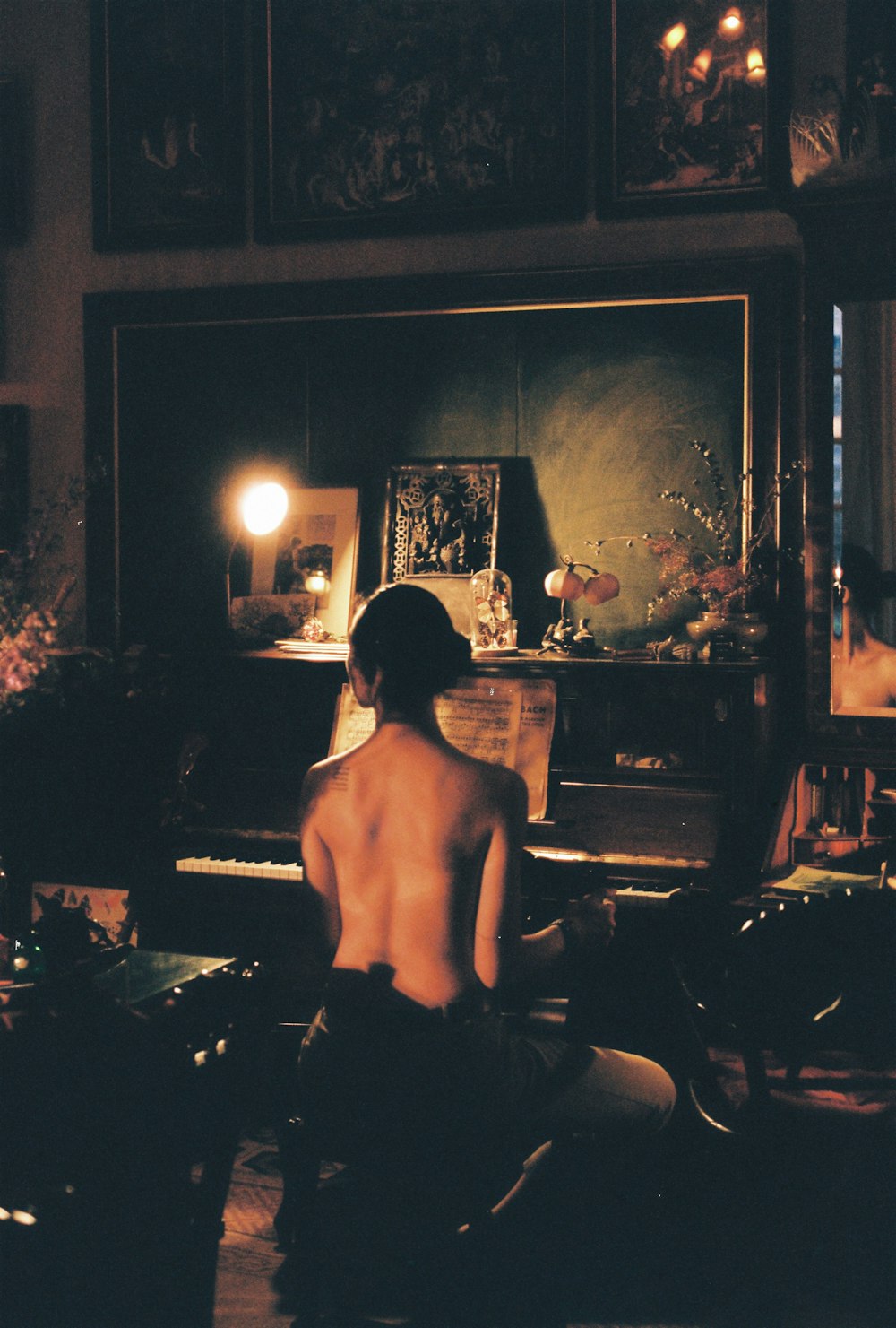 a naked man sitting in front of a piano