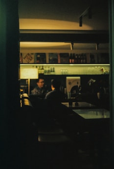 A cozy, dimly lit café in Lyon where two people share a flirtatious glance.