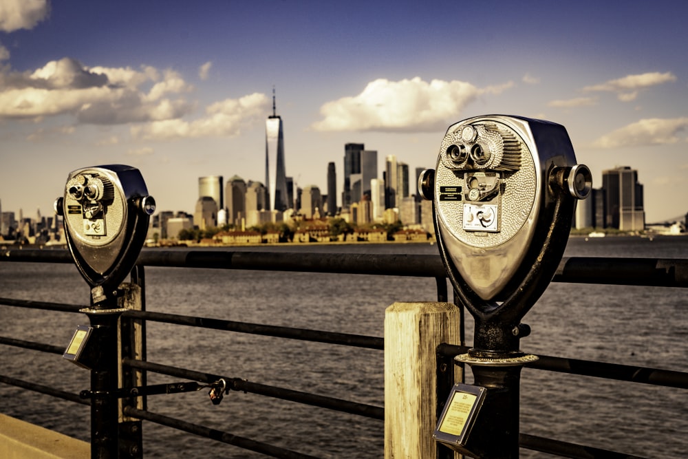 two coin operated binoculars overlooking a city skyline