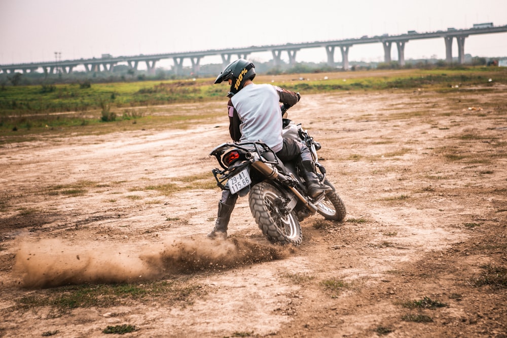 a man riding a dirt bike on top of a dirt field