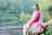 A smiling woman enjoying the peaceful garden at Sanskriti Stay in Rishikesh.